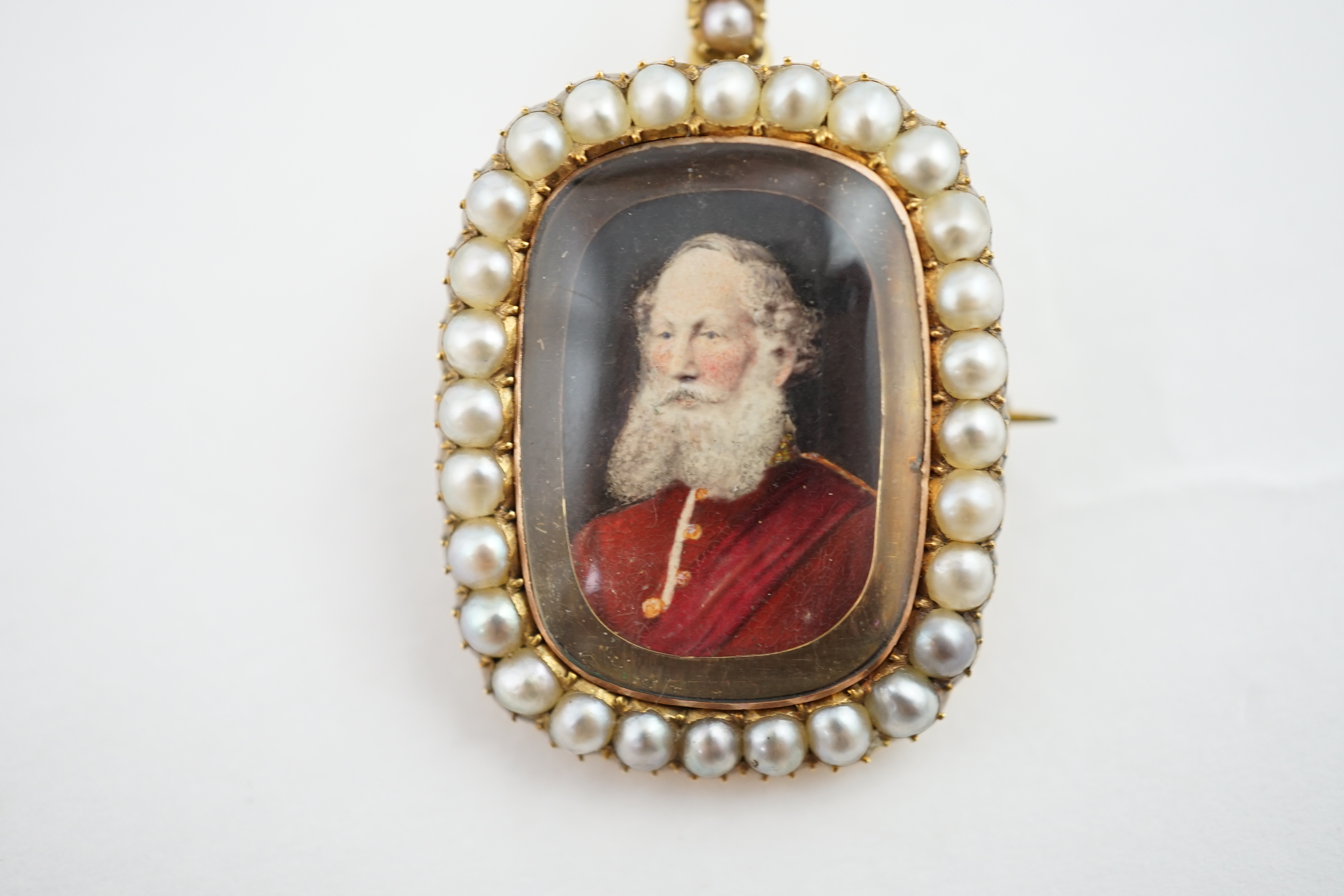 An early Victorian split pearl set gold pendant brooch, inset with a portrait miniature of bearded gentleman in uniform